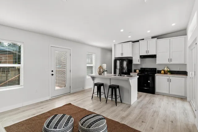 a kitchen with a refrigerator and a stove top oven