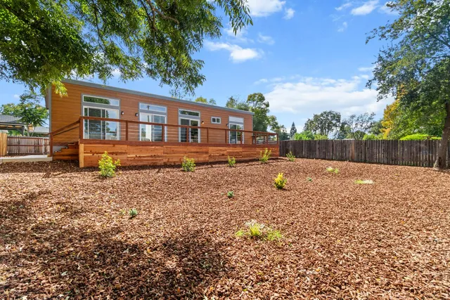 a backyard of a house with table and chairs