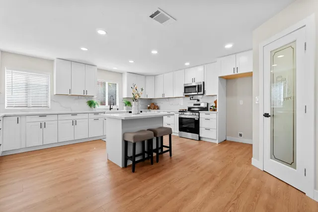 a kitchen with stainless steel appliances a refrigerator sink and cabinets