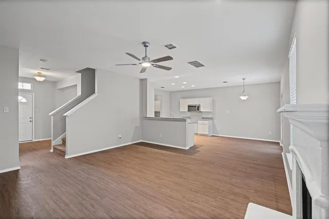 a view of a kitchen with wooden floor and a ceiling fan