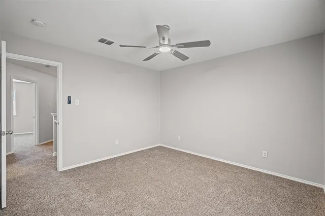 an empty room with a ceiling fan and a window