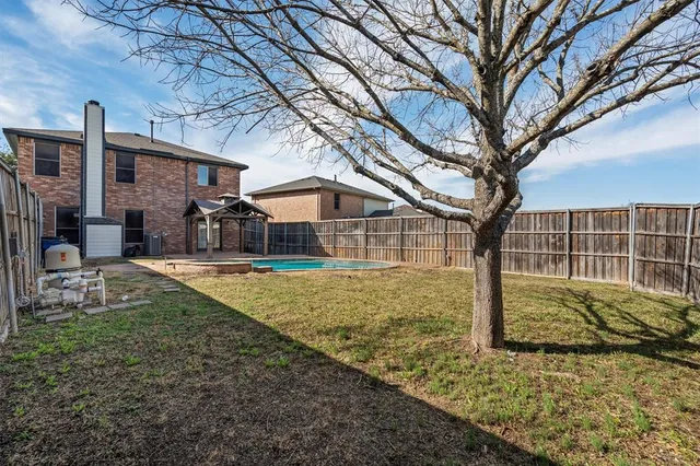 a view of a house with backyard and trees