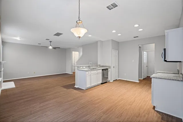 a kitchen with granite countertop a stove and a wooden floors