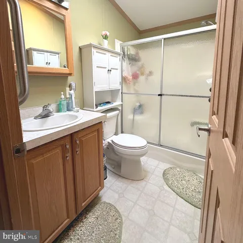 a bathroom with a granite countertop sink toilet a mirror and shower