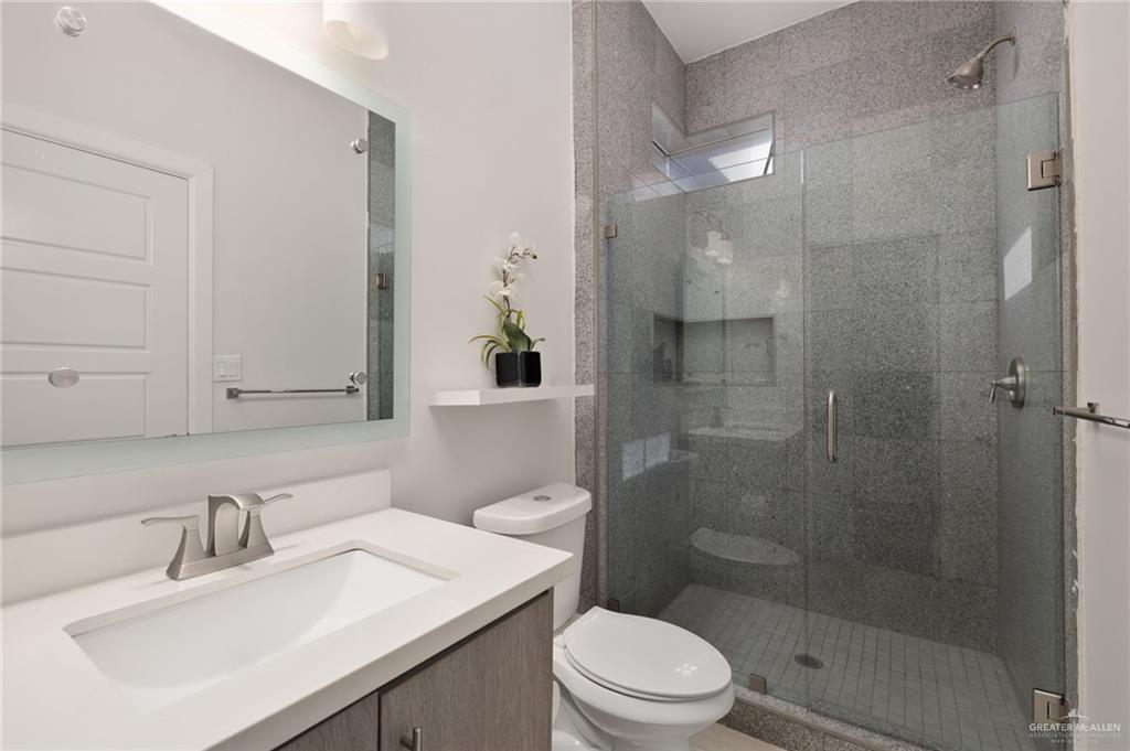 801 East Azucar Avenue Pharr, TX 78577 - Photo 14 of 19 Bathroom with a shower stall, toilet, and vanity