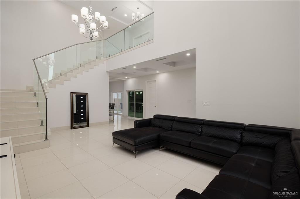 801 East Azucar Avenue Pharr, TX 78577 - Photo 4 of 19 Living room featuring light tile patterned floors, stairway, an inviting chandelier, and a towering ceiling