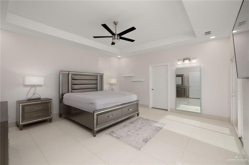 801 East Azucar Avenue Pharr, TX 78577 - Photo 8 of 19 Bedroom featuring light tile patterned flooring, visible vents, a raised ceiling, and baseboards