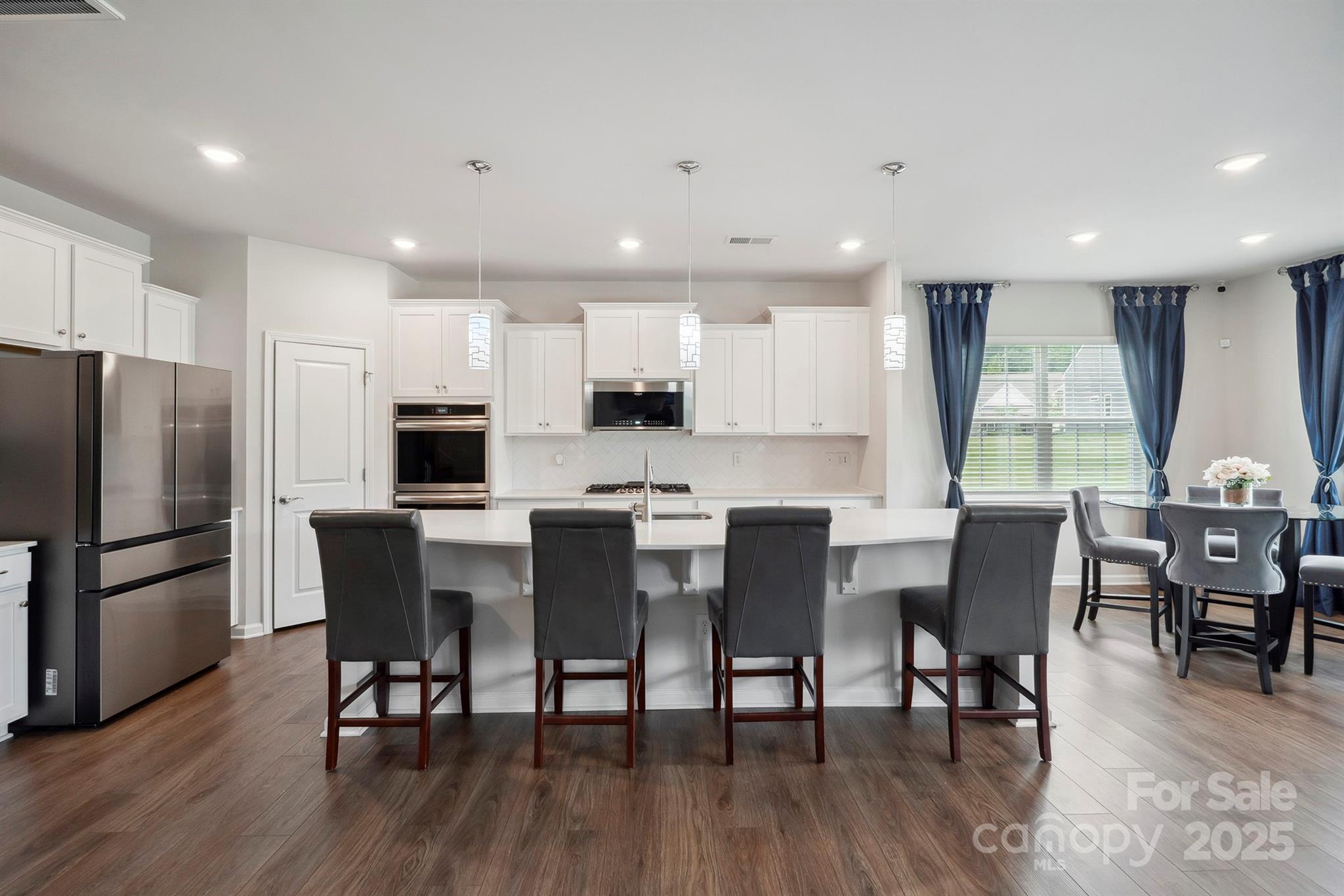 4015 Havenport Circle Fort Mill, SC 29708 - Photo 7 of 47 a kitchen with stainless steel appliances granite countertop a dining table chairs refrigerator microwave and cabinets