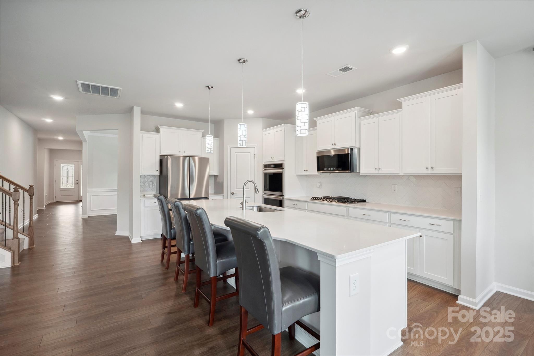 4015 Havenport Circle Fort Mill, SC 29708 - Photo 8 of 47 a kitchen with a dining table chairs wooden floor appliances and cabinets