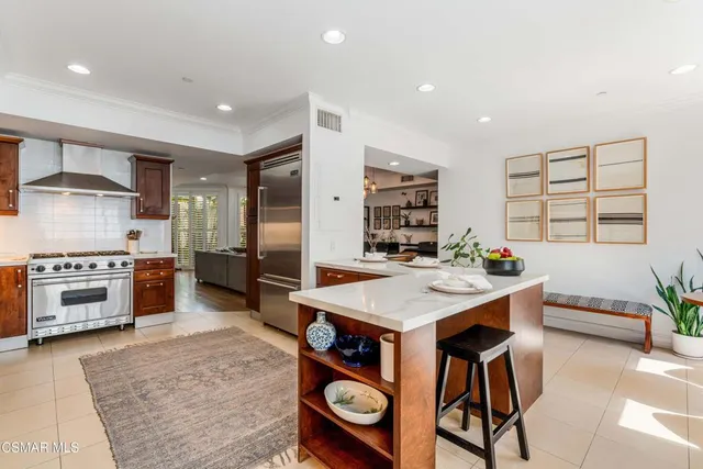 a kitchen with stainless steel appliances kitchen island granite countertop a table and chairs in it