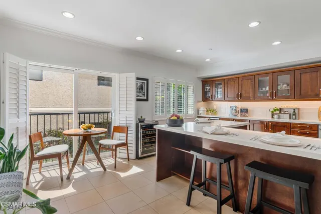 a kitchen with stainless steel appliances granite countertop a stove a sink a dining table and chairs