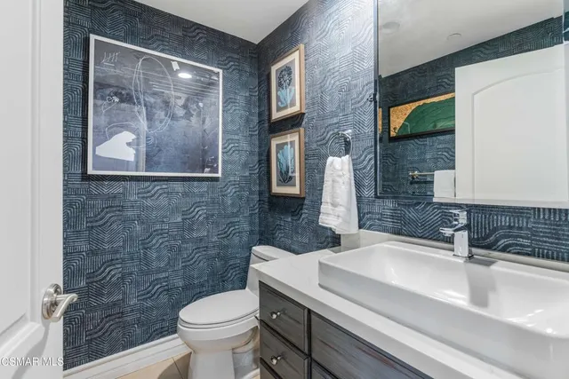 a bathroom with a sink a toilet and a mirror