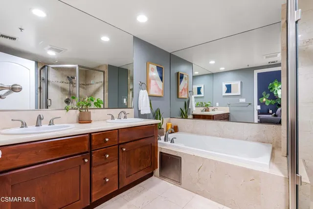 a spacious bathroom with a tub sink and mirror