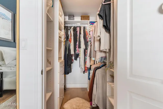 a view of walk in closet with clothes and shoes
