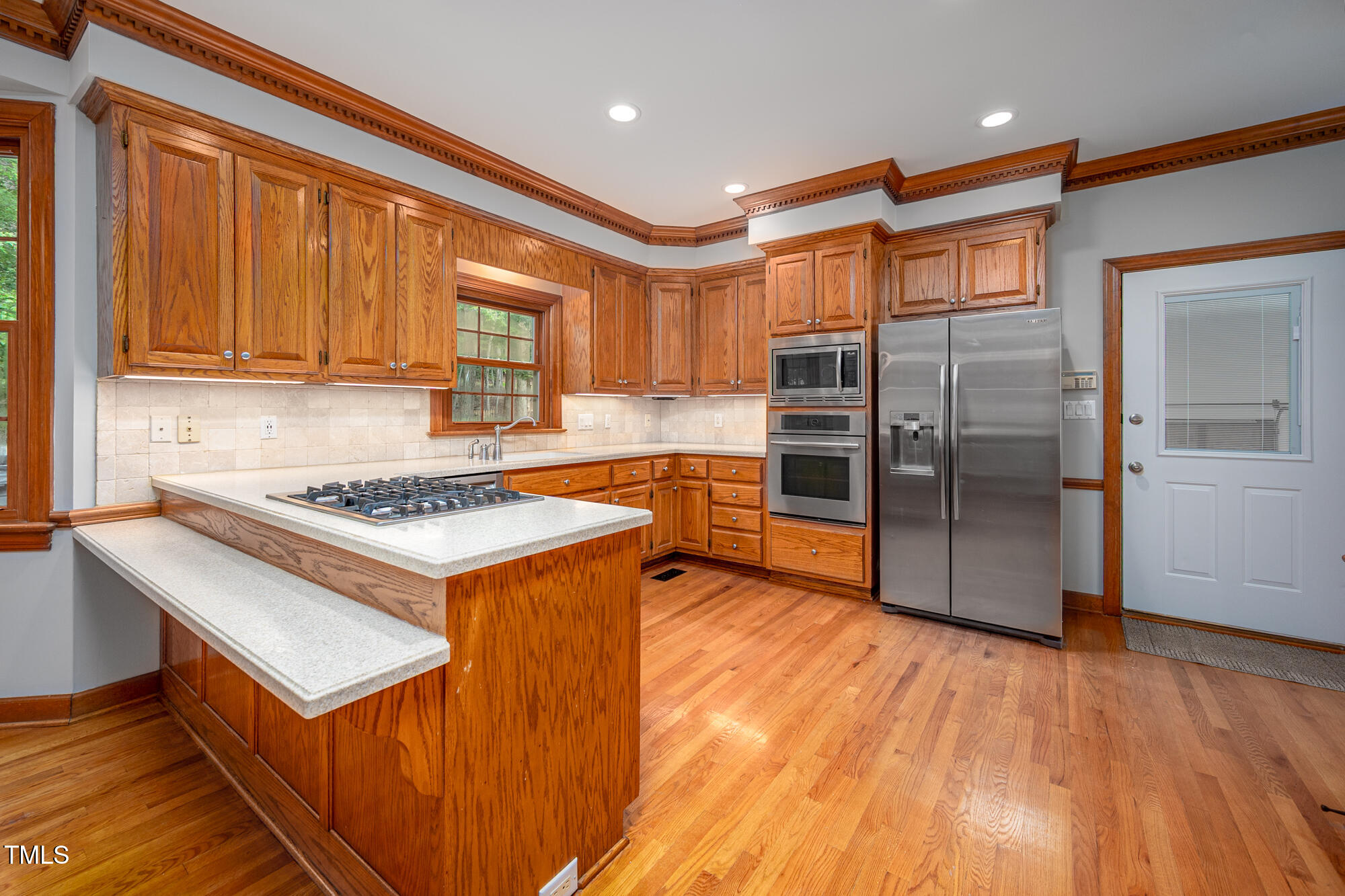 5611 Red Coach Road Durham, NC 27712 - Photo 13 of 51 a kitchen that has a kitchen island wooden cabinets and a refrigerator