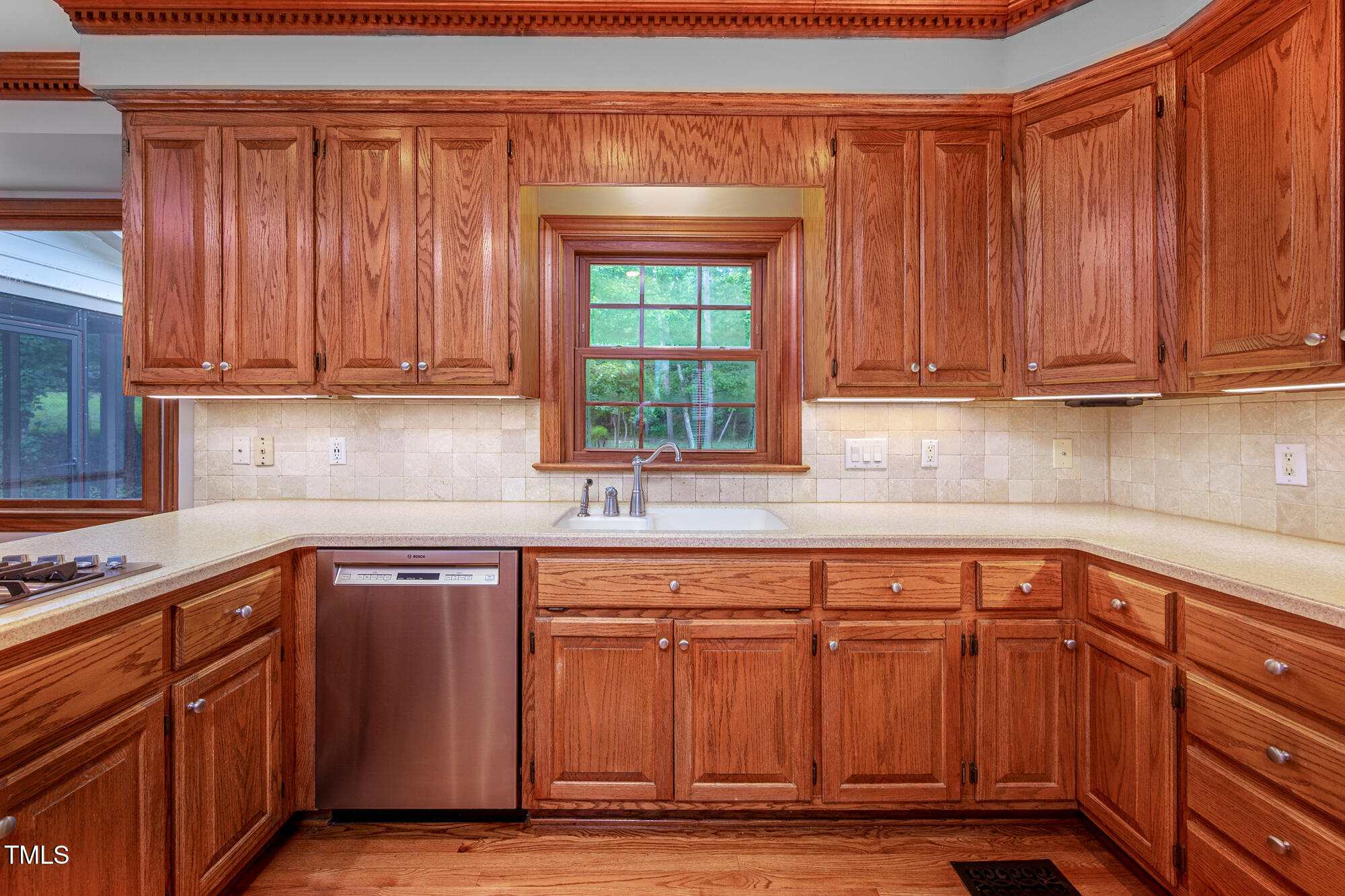 5611 Red Coach Road Durham, NC 27712 - Photo 15 of 51 a kitchen with granite countertop wooden cabinets a sink and dishwasher