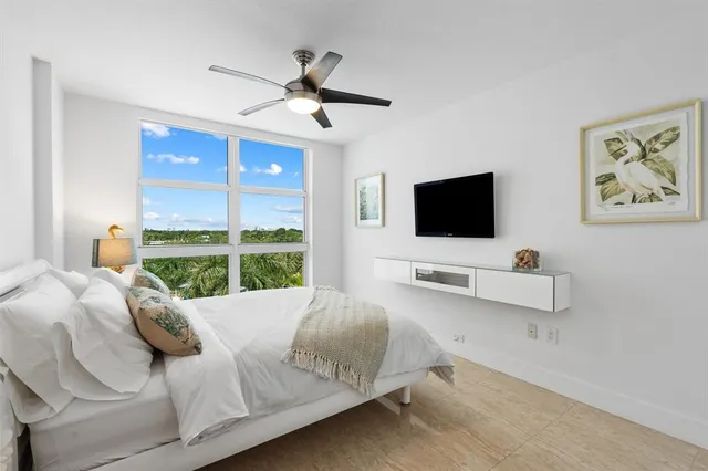a living room with a bed furniture and a flat screen tv
