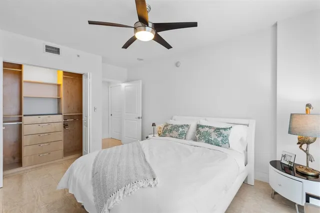 a bedroom with a bed and a lamp on the dresser