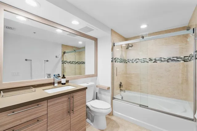 a bathroom with a double vanity sink toilet mirror and shower