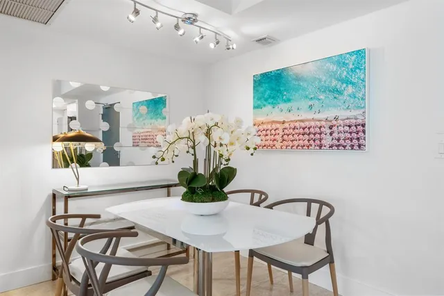 a dining room with furniture and a potted plant