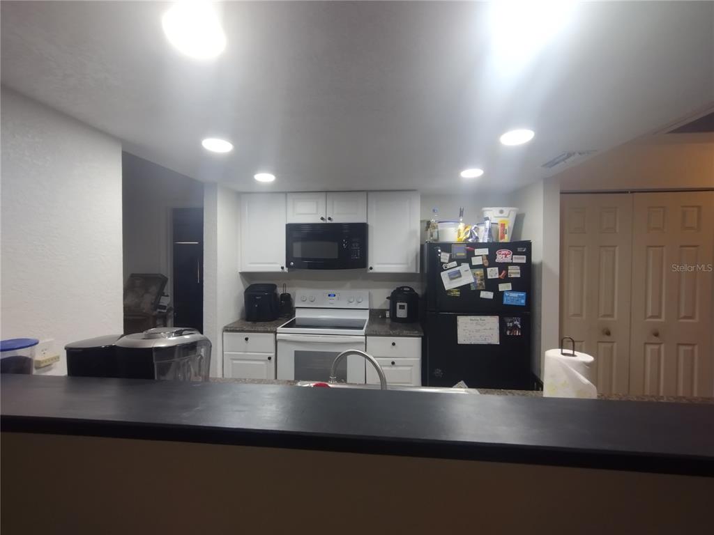 2419 Appian Avenue Spring Hill, FL 34608 - Photo 7 of 21 a kitchen with stainless steel appliances kitchen island sink refrigerator and microwave