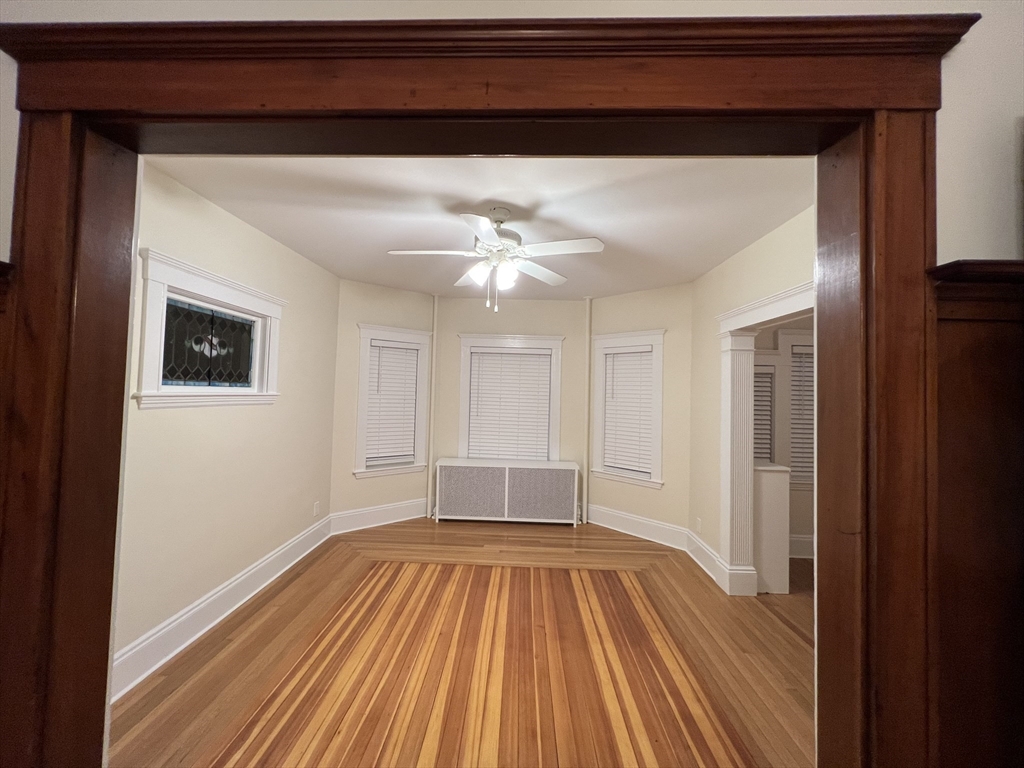 67 Commonwealth Road, Unit 1 Watertown, MA 02472 - Photo 12 of 22 a view of a room with wooden floor and ceiling fan