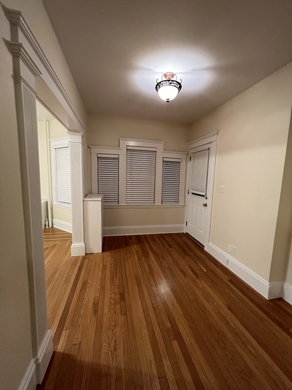 67 Commonwealth Road, Unit 1 Watertown, MA 02472 - Photo 14 of 22 wooden floor in an empty room with a window