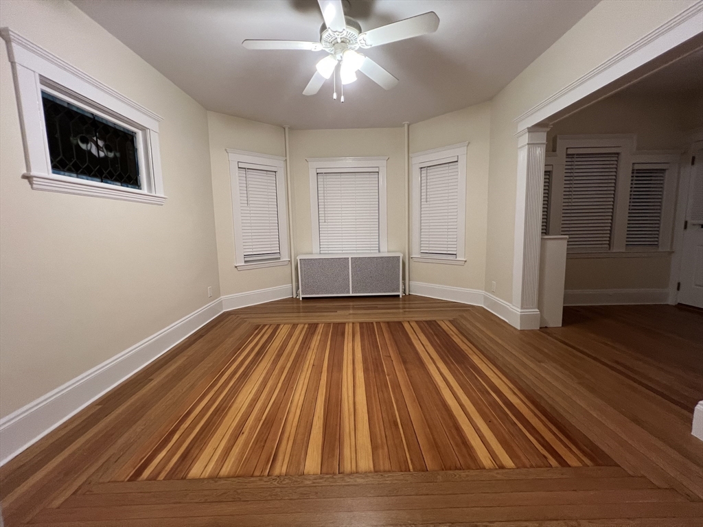 67 Commonwealth Road, Unit 1 Watertown, MA 02472 - Photo 16 of 22 a view of empty room with wooden floor and ceiling fan