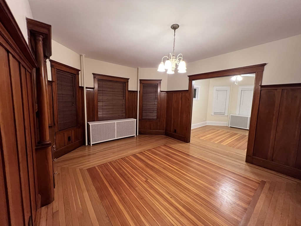 67 Commonwealth Road, Unit 1 Watertown, MA 02472 - Photo 18 of 22 a view of a livingroom with wooden floor staircase and a kitchen space