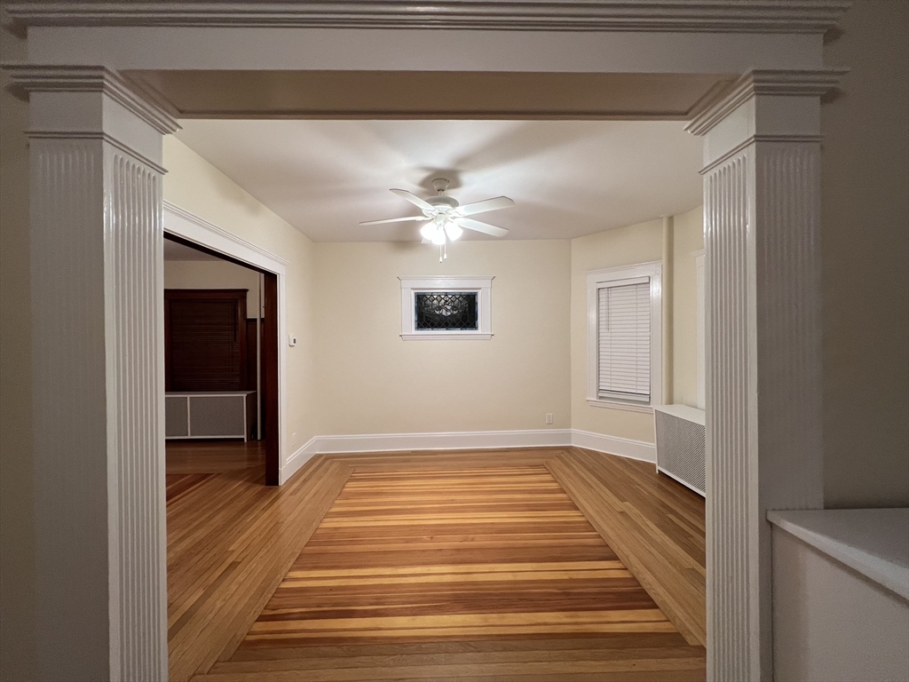 67 Commonwealth Road, Unit 1 Watertown, MA 02472 - Photo 19 of 22 a view of an empty room with wooden floor and a window