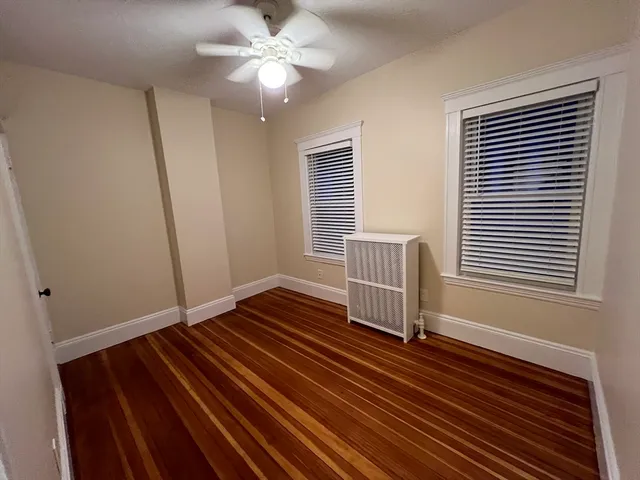 a view of room with window ceiling fan and wooden floor