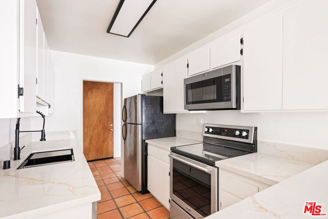 a kitchen with stainless steel appliances a stove a microwave and a refrigerator