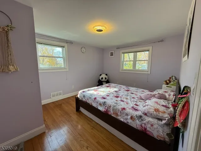 a bedroom with bed and wooden floor