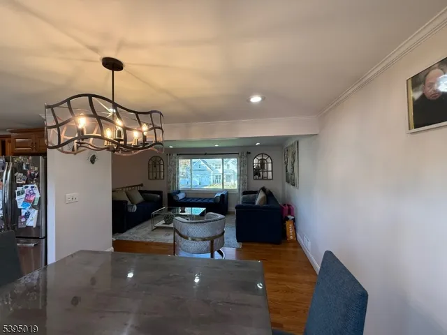 a view of a dining room with furniture a chandelier and wooden floor