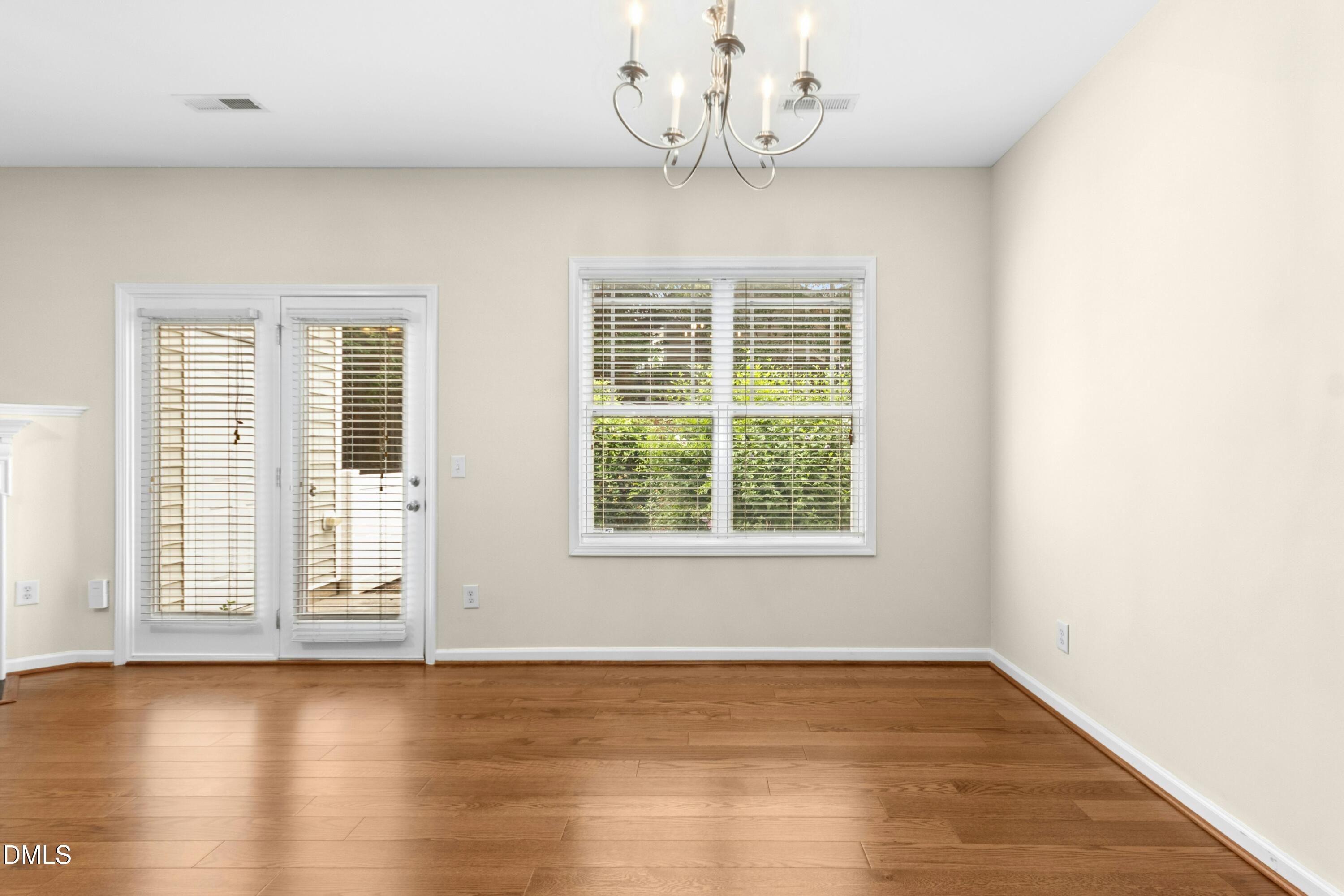 5541 Nur Lane Raleigh, NC 27606 - Photo 8 of 33 an empty room with wooden floor and windows