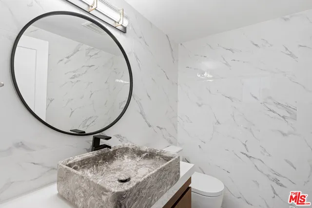 a bathroom with a sink a toilet and a mirror