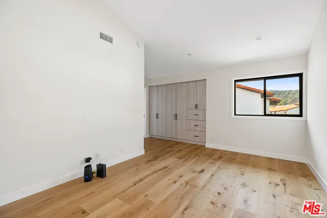 a view of a room with wooden floor and a ceiling fan