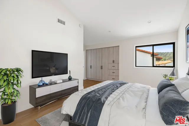 a bedroom with a bed and a flat screen tv