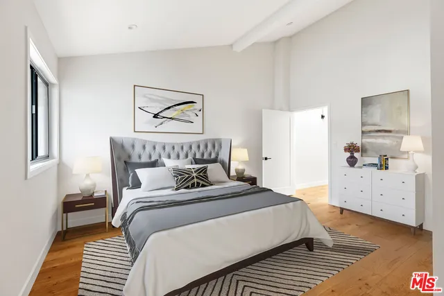 a bedroom with a bed and wooden floor