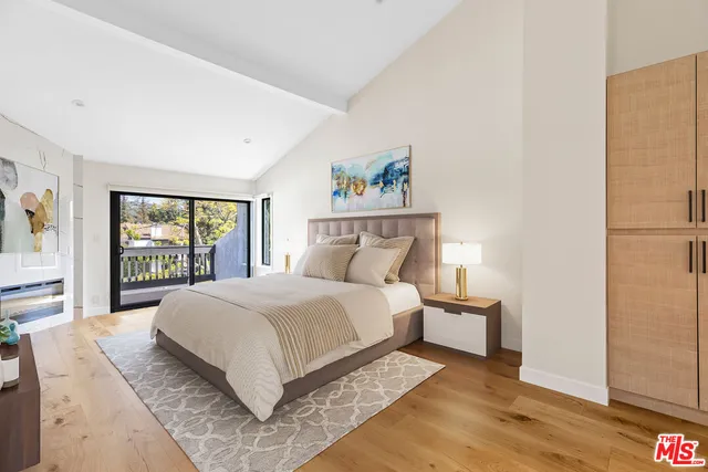 a large bed sitting in a bedroom next to a window