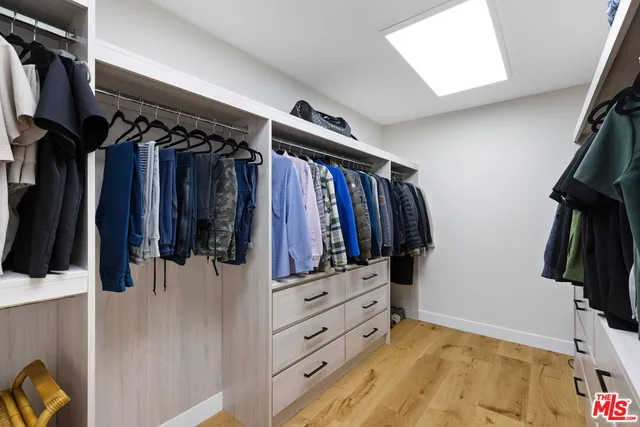 a view of walk in closet with clothes and shoes