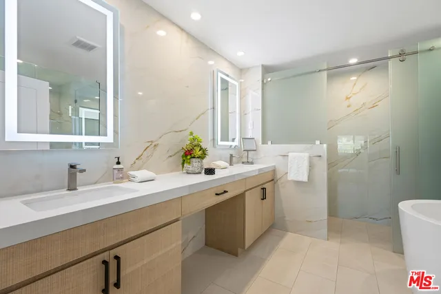 a bathroom with a double vanity sink mirror and toilet