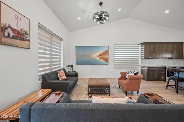 a living room with furniture kitchen view and a chandelier
