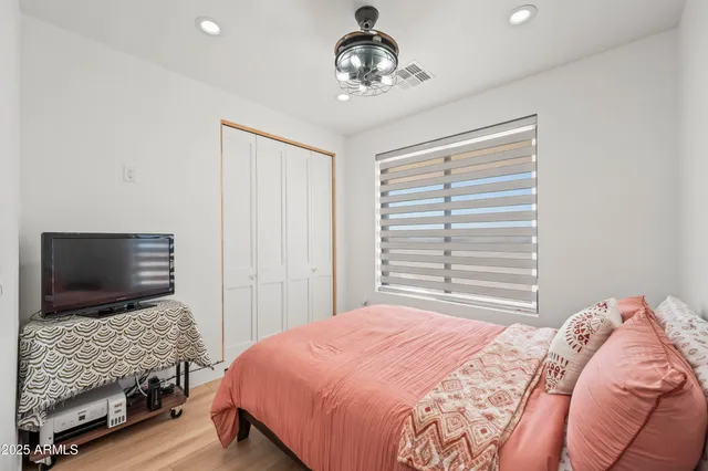 a bedroom with a bed and a flat screen tv