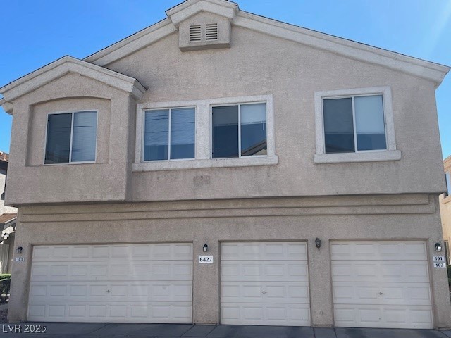 6427 Rusticated Stone Avenue, Unit 101 Henderson, NV 89011 - Photo 1 of 12 Back of house with stucco siding and an attached garage