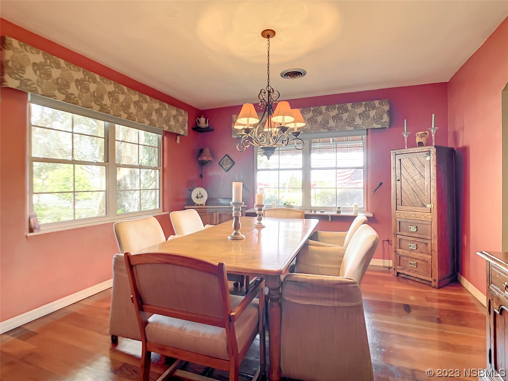 418 North Riverside Drive Edgewater, FL 32132 - Photo 15 of 48 a dining room with furniture a chandelier and wooden floor