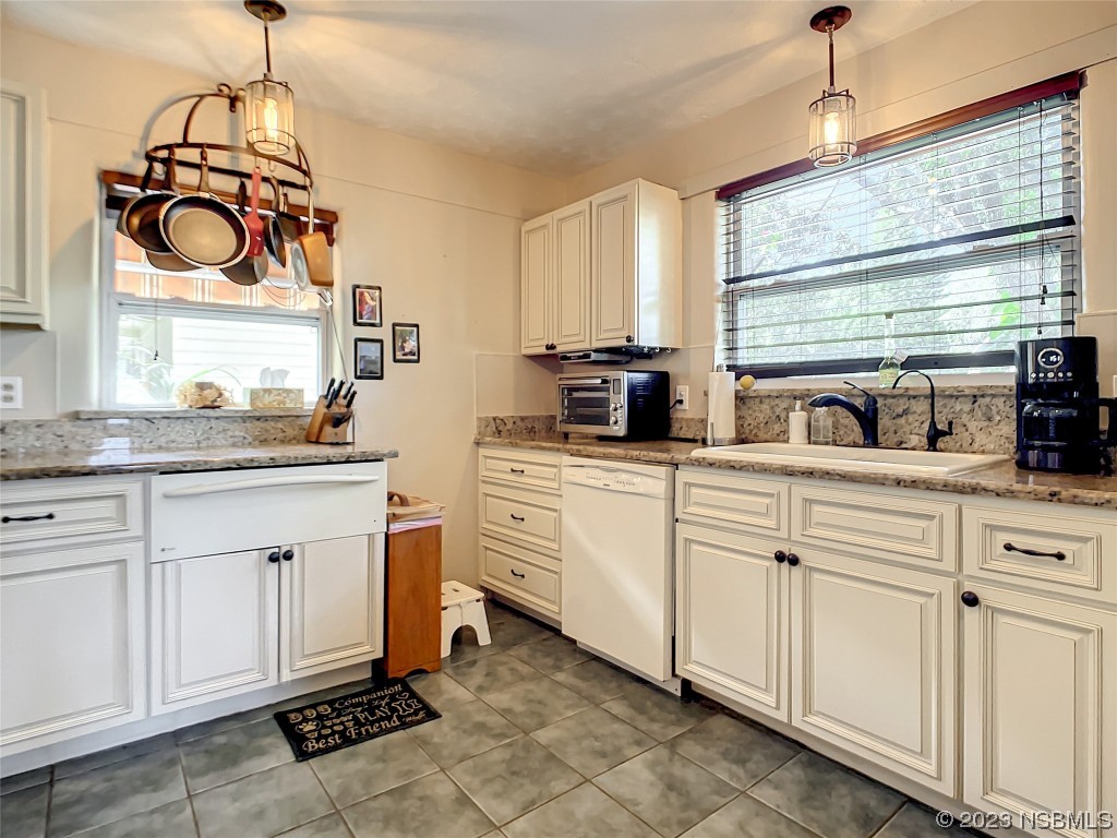 418 North Riverside Drive Edgewater, FL 32132 - Photo 18 of 48 a kitchen with white cabinets and white appliances