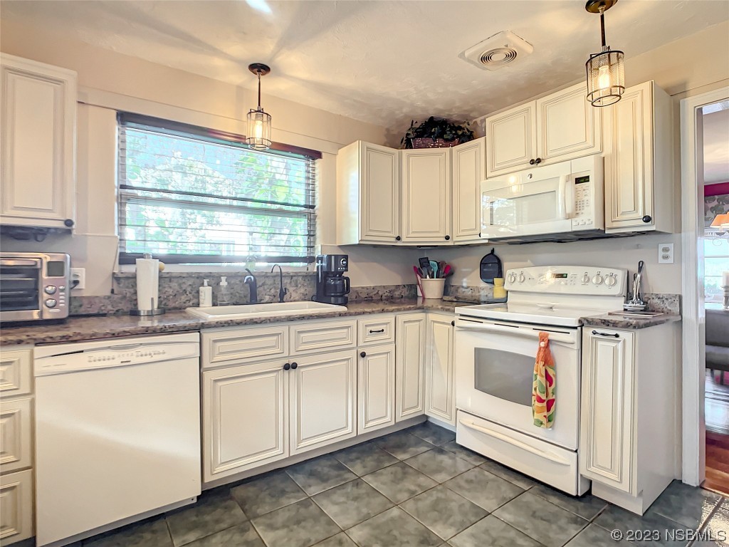 418 North Riverside Drive Edgewater, FL 32132 - Photo 21 of 48 a kitchen with stainless steel appliances granite countertop a sink window and cabinets