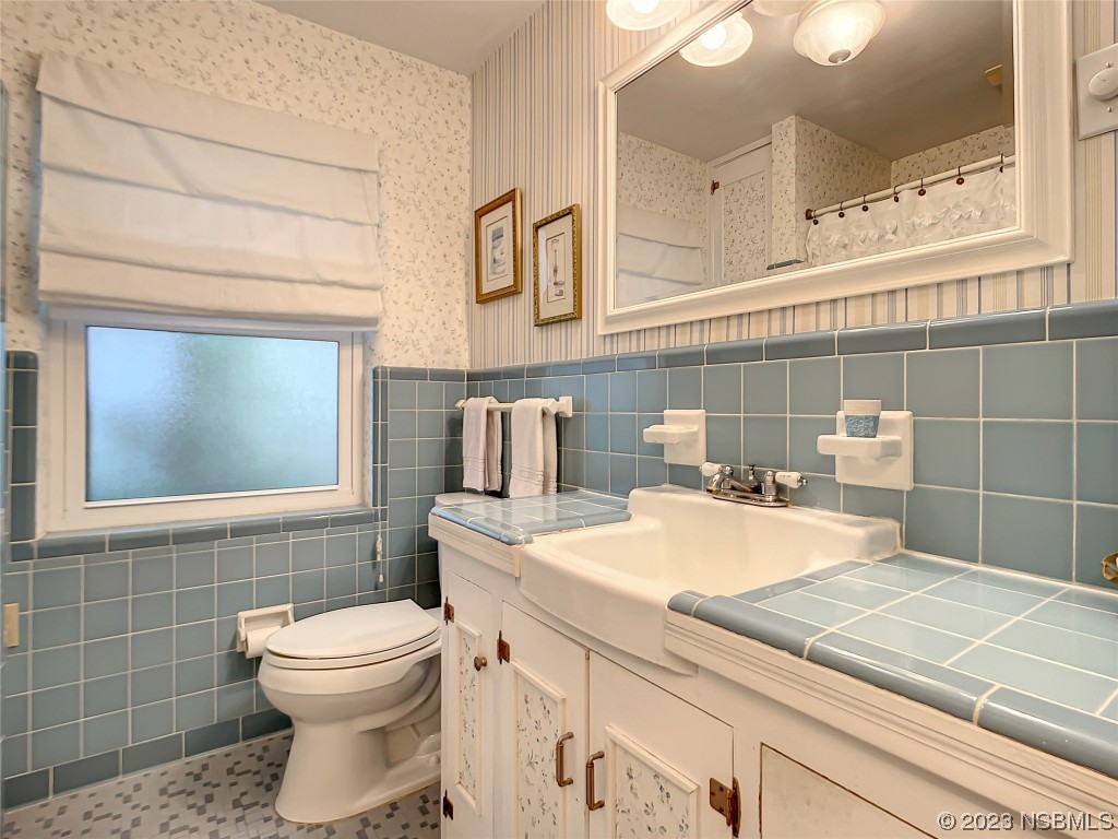 418 North Riverside Drive Edgewater, FL 32132 - Photo 33 of 48 a bathroom with a sink a toilet and mirror