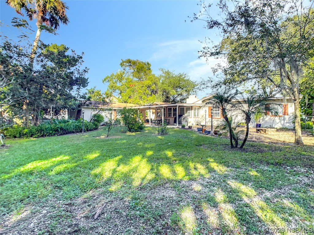 418 North Riverside Drive Edgewater, FL 32132 - Photo 45 of 48 a view of backyard with table and chairs and large trees